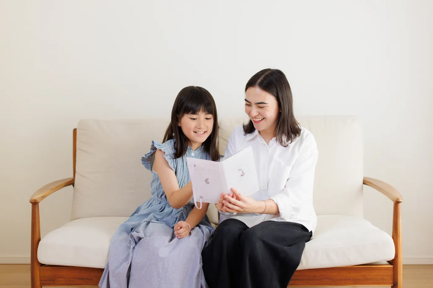 CareFinder sitter and a young girl reading together on a sofa
